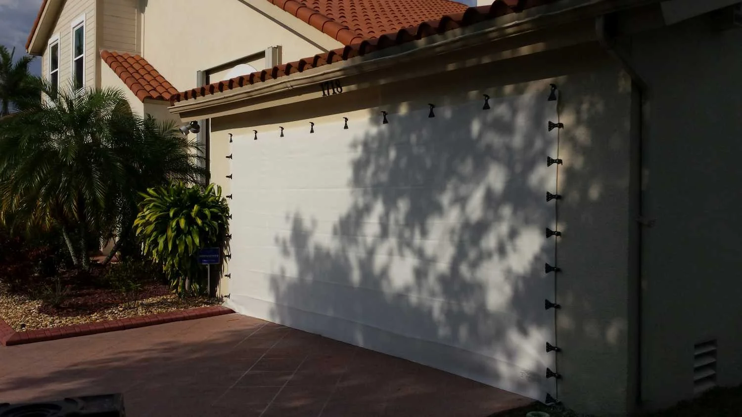 Garage door protected with AstroGuard hurricane fabric — before and after Los Cabos